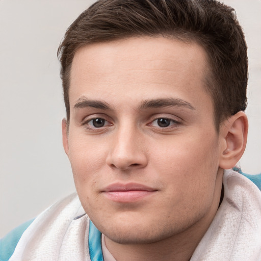 Joyful white young-adult male with short  brown hair and grey eyes