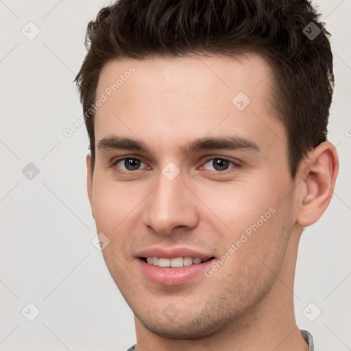 Joyful white young-adult male with short  brown hair and brown eyes