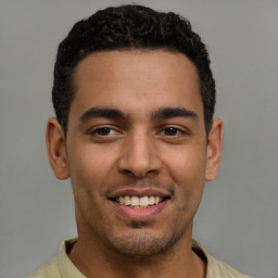 Joyful latino young-adult male with short  black hair and brown eyes