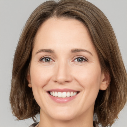 Joyful white young-adult female with medium  brown hair and green eyes