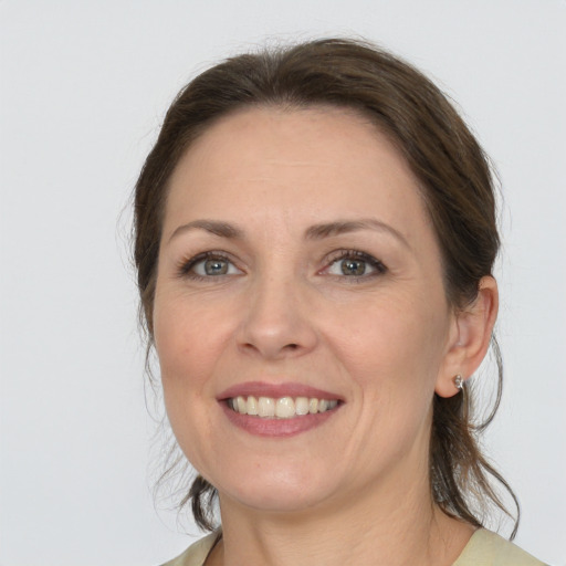 Joyful white adult female with medium  brown hair and grey eyes