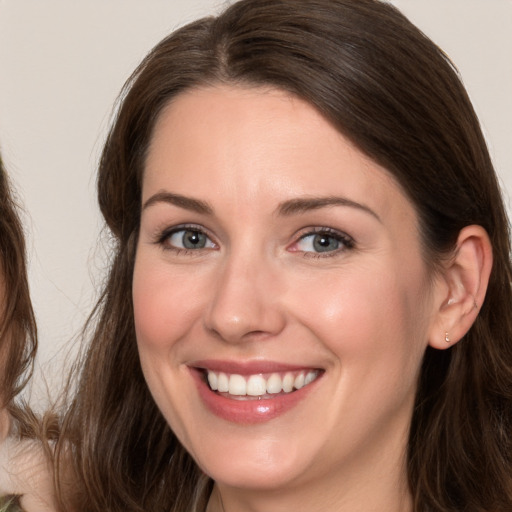 Joyful white young-adult female with long  brown hair and brown eyes