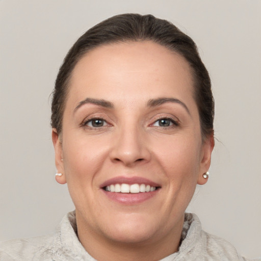 Joyful white young-adult female with short  brown hair and grey eyes