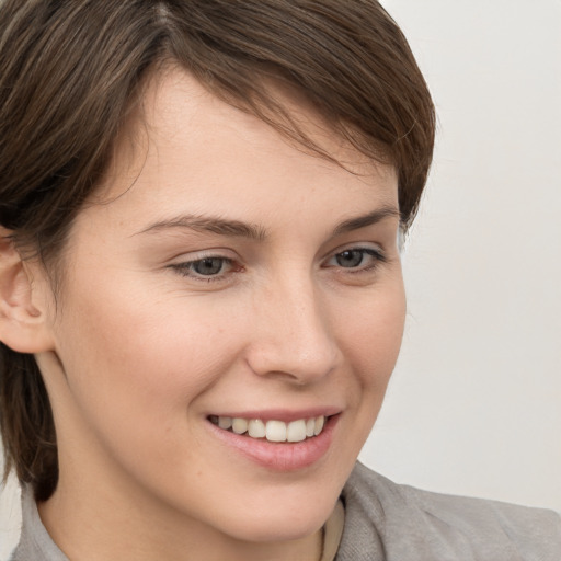 Joyful white young-adult female with medium  brown hair and grey eyes