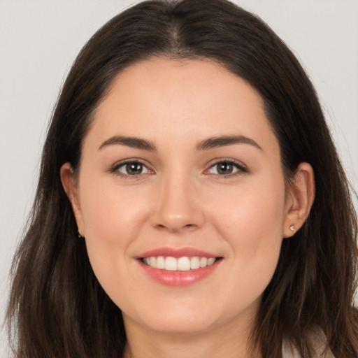 Joyful white young-adult female with long  brown hair and brown eyes