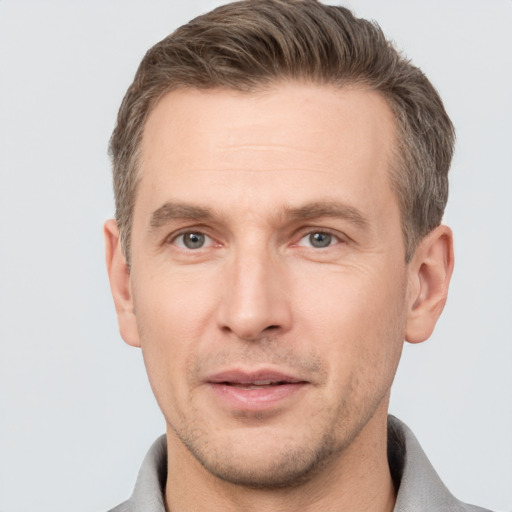 Joyful white adult male with short  brown hair and grey eyes