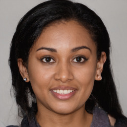 Joyful latino young-adult female with medium  brown hair and brown eyes