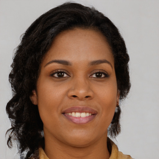 Joyful black young-adult female with medium  brown hair and brown eyes