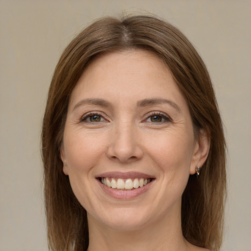 Joyful white adult female with long  brown hair and green eyes