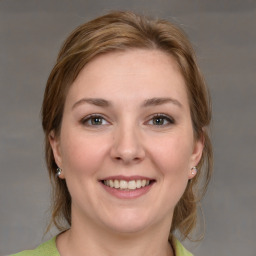 Joyful white young-adult female with medium  brown hair and grey eyes