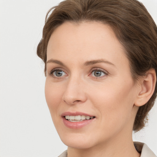 Joyful white young-adult female with medium  brown hair and grey eyes