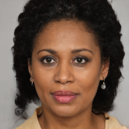 Joyful black adult female with long  brown hair and brown eyes