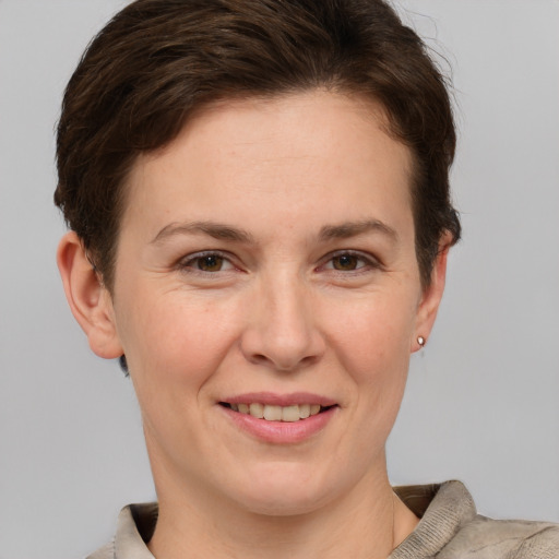 Joyful white adult female with short  brown hair and grey eyes