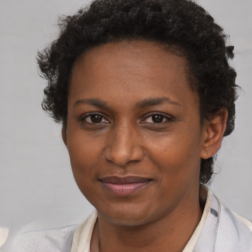 Joyful black young-adult female with short  brown hair and brown eyes