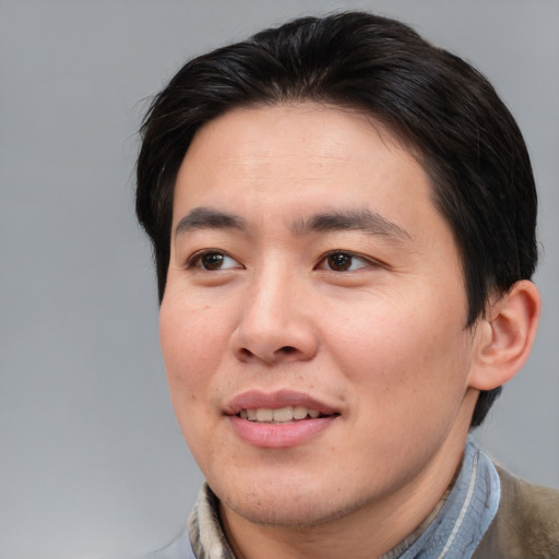 Joyful asian adult male with medium  brown hair and brown eyes
