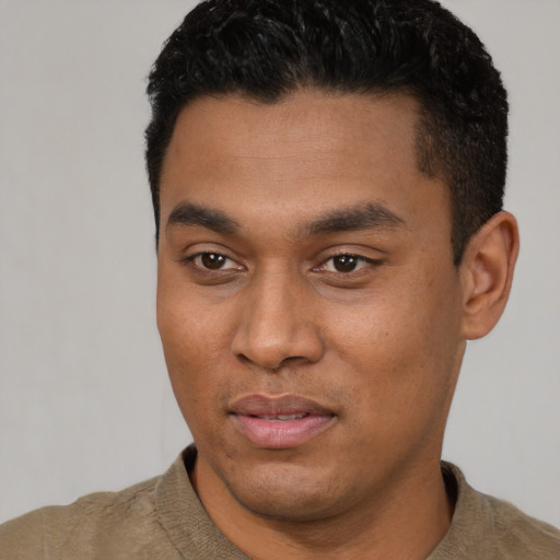 Joyful latino young-adult male with short  black hair and brown eyes