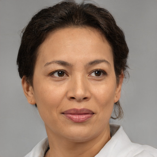 Joyful latino adult female with medium  brown hair and brown eyes