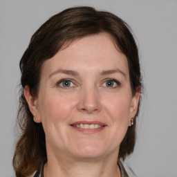 Joyful white adult female with medium  brown hair and grey eyes