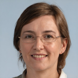 Joyful white adult female with medium  brown hair and grey eyes