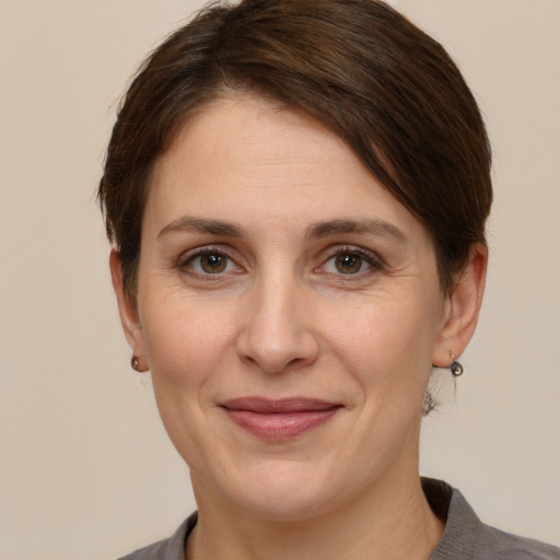 Joyful white adult female with short  brown hair and grey eyes