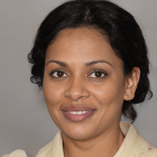 Joyful black adult female with medium  brown hair and brown eyes