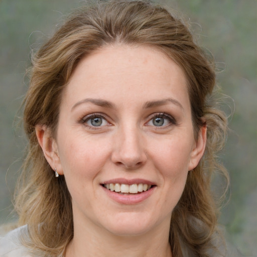 Joyful white adult female with medium  brown hair and green eyes