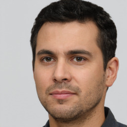 Joyful white young-adult male with short  black hair and brown eyes