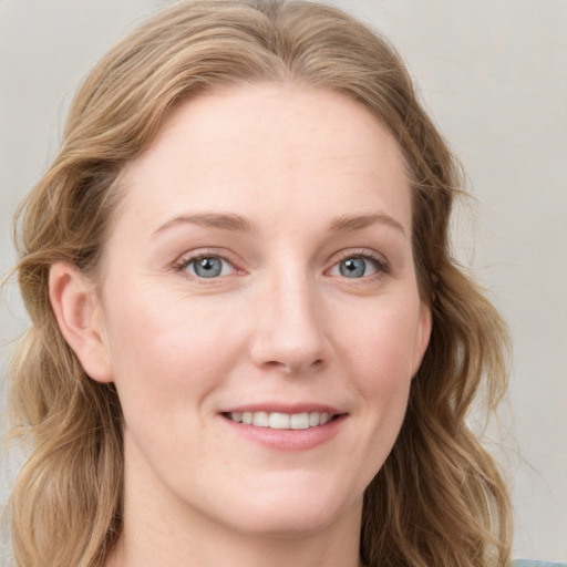 Joyful white young-adult female with long  brown hair and blue eyes