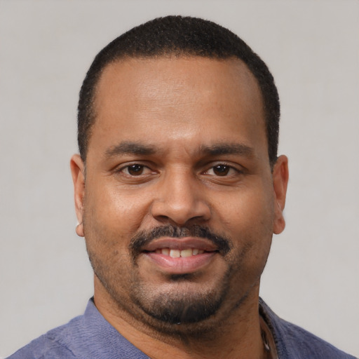 Joyful latino adult male with short  black hair and brown eyes