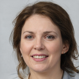 Joyful white adult female with medium  brown hair and grey eyes