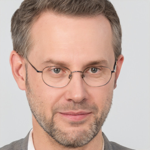 Joyful white adult male with short  brown hair and grey eyes