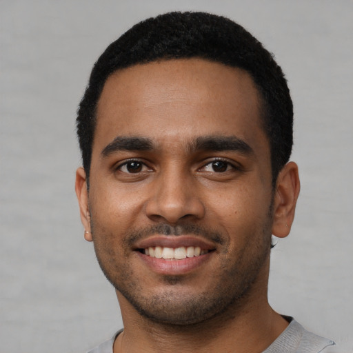 Joyful black young-adult male with short  black hair and brown eyes