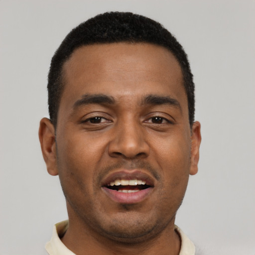Joyful black young-adult male with short  black hair and brown eyes