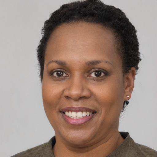 Joyful black adult female with short  brown hair and brown eyes