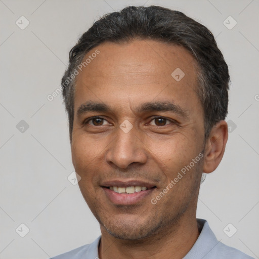 Joyful latino adult male with short  black hair and brown eyes