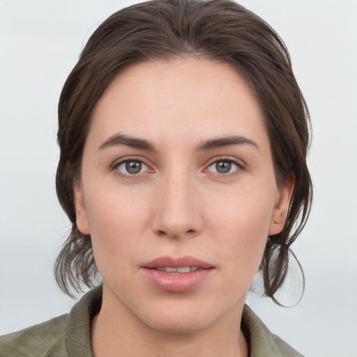 Joyful white young-adult female with medium  brown hair and grey eyes