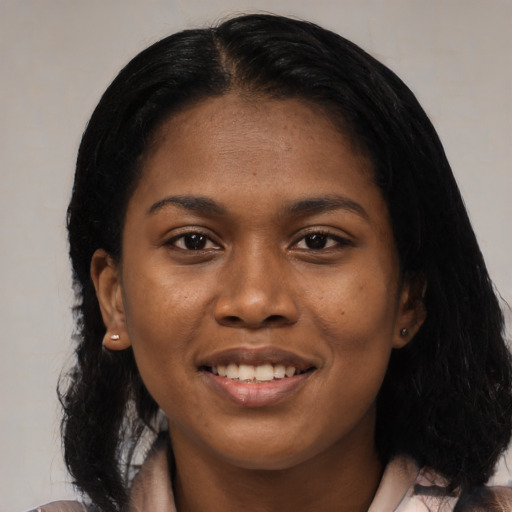 Joyful black young-adult female with long  black hair and brown eyes