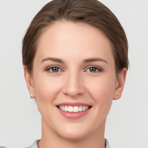 Joyful white young-adult female with short  brown hair and grey eyes