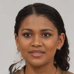 Joyful black young-adult female with long  brown hair and brown eyes