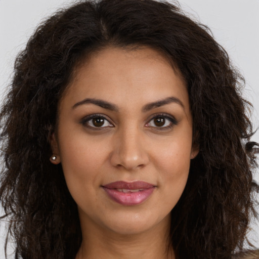 Joyful latino young-adult female with long  brown hair and brown eyes