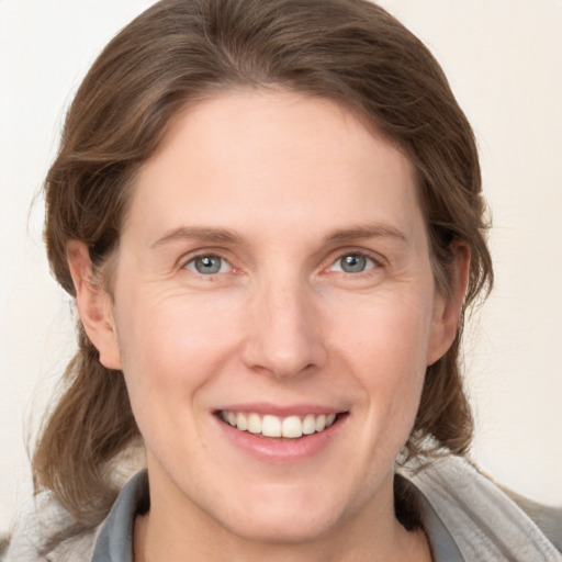 Joyful white adult female with medium  brown hair and grey eyes