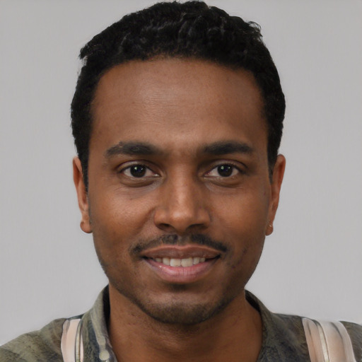 Joyful black young-adult male with short  black hair and brown eyes