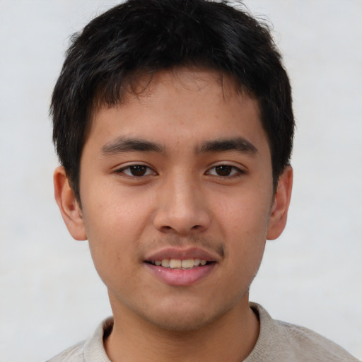 Joyful asian young-adult male with short  brown hair and brown eyes