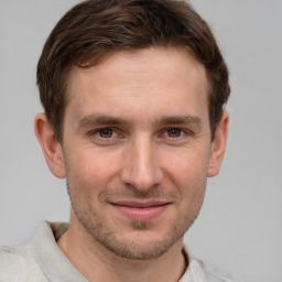 Joyful white young-adult male with short  brown hair and grey eyes