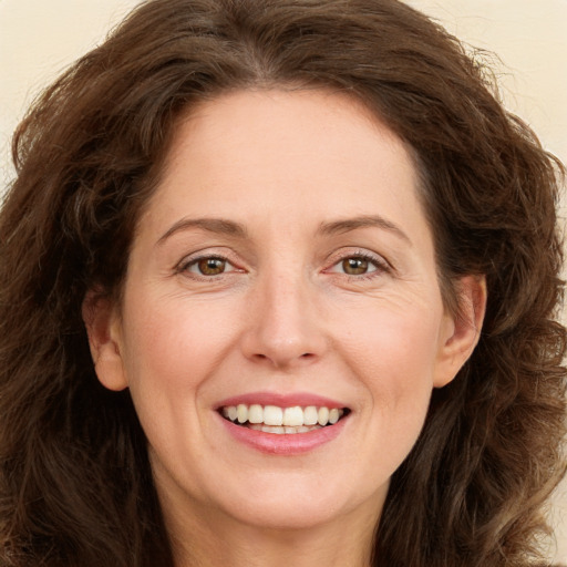 Joyful white adult female with long  brown hair and green eyes