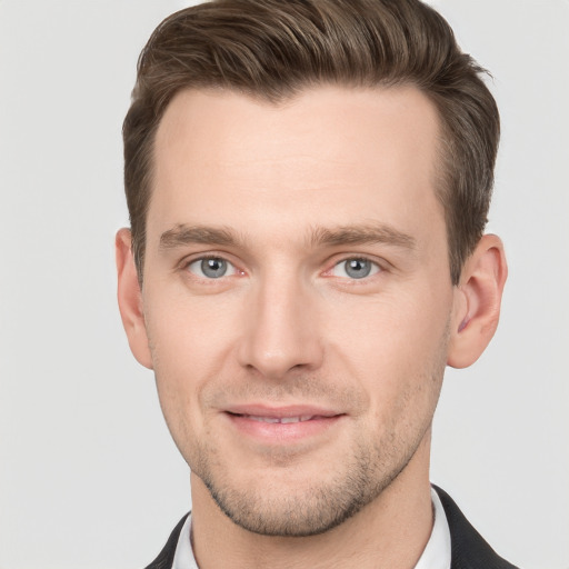 Joyful white young-adult male with short  brown hair and grey eyes