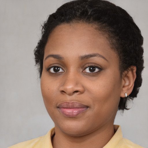 Joyful black young-adult female with short  brown hair and brown eyes