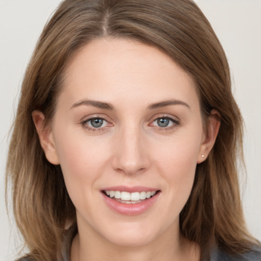 Joyful white young-adult female with long  brown hair and grey eyes