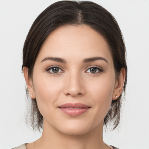 Joyful white young-adult female with medium  brown hair and grey eyes