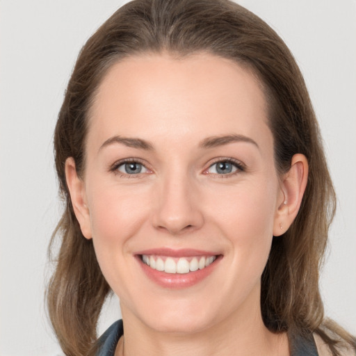 Joyful white young-adult female with long  brown hair and grey eyes